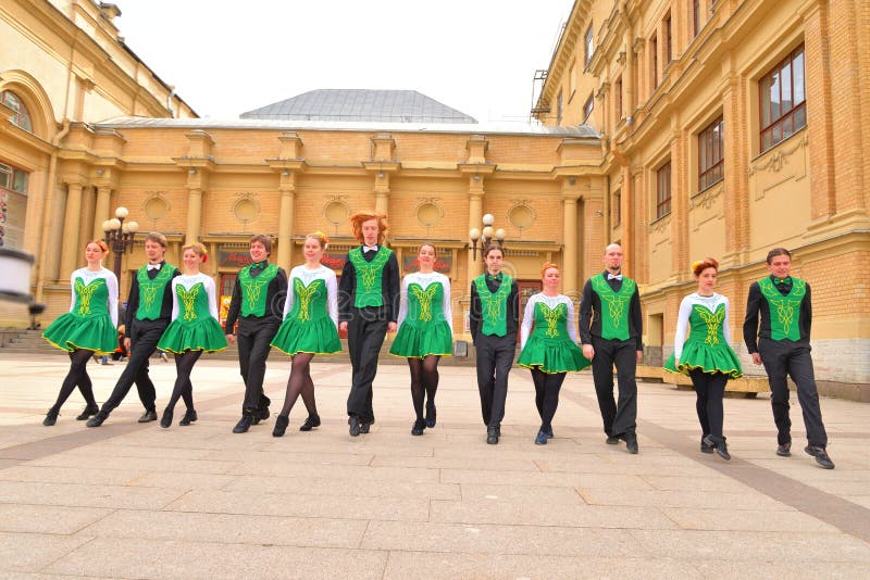 Group of people in national costumes are dancing Irish dances.