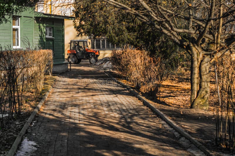 St Petersburg, Rússia, 03/15/2017 - mini trabalho do trator no jardim botânico imagem de stock St Petersburg, Rússia, 03/15/2017 - mini trabalho do trator no jardim botânico imagem de stock