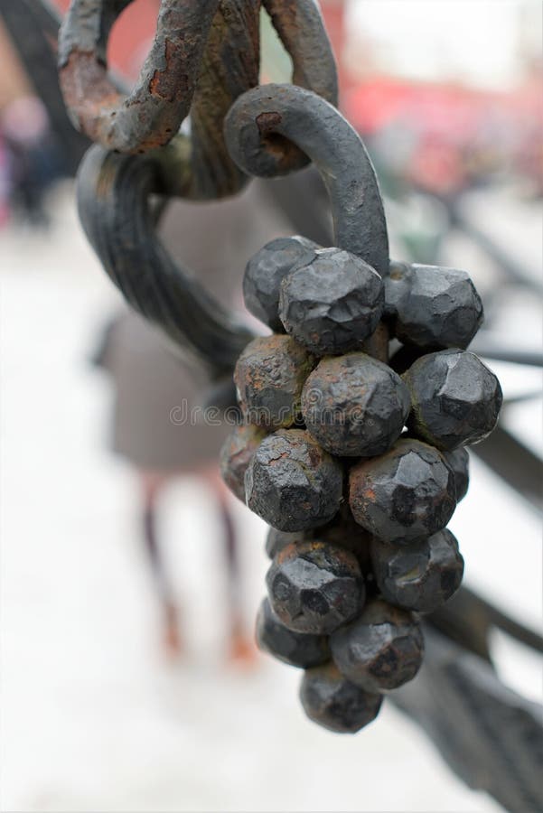 St Petersburg, Rússia, o 10 de março de 2019 Fragmento de uma cerca forjada do metal sob a forma de um grupo de uvas imagens de stock St Petersburg, Rússia, o 10 de março de 2019 Fragmento de uma cerca forjada do metal sob a forma de um grupo de uvas imagens de stock