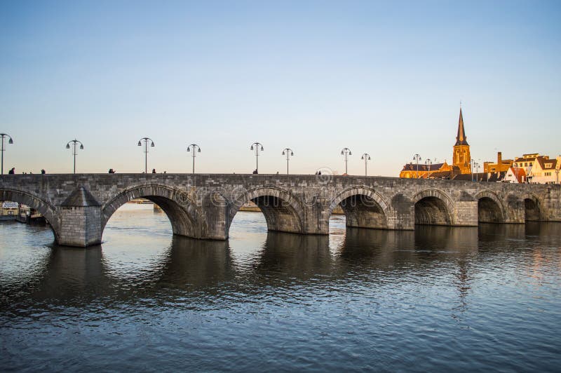 St. Servatius Bridge in Maastricht and a church illuminated by fading winter sunlight. St. Servatius Bridge in Maastricht and a church illuminated by fading winter sunlight.