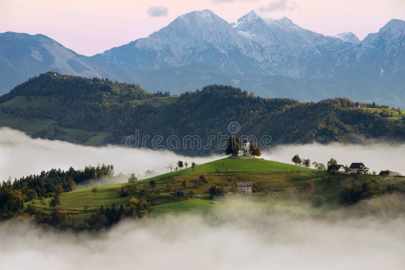 St Thomas bergkerk in Slovenië in een mistige zonsopgang stock foto St Thomas bergkerk in Slovenië in een mistige zonsopgang stock foto