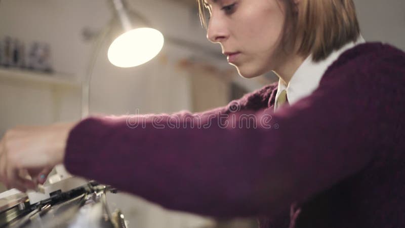 Stabilisierter Thread der kreativen Frau auf Webstuhlmaschine für spinnendes Gewebe in der Werkstatt