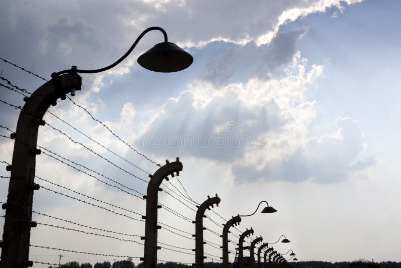 Stacheldrahtzaun unter beeindruckendem Himmel. Auschwitz lizenzfreie stockbilder