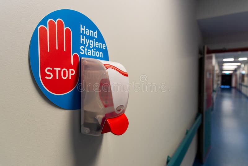 Hand hygiene station in a hospital hall way , stop sign. Hand hygiene station in a hospital hall way , stop sign