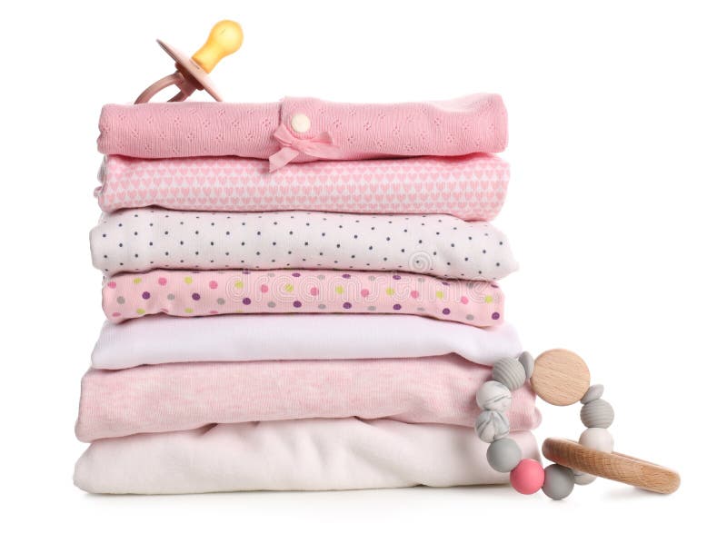 Stack of Baby Girl`s Clothes, Pacifier and Rattle on White Background