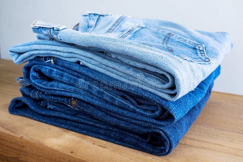 Stack of Blue Jeans on Wooden Table. Stock Photo Image of clothes