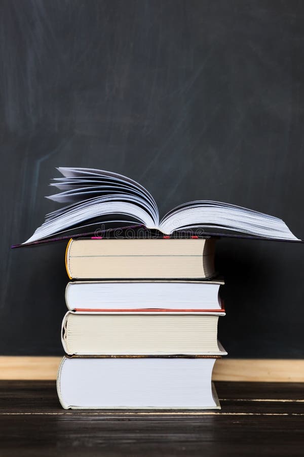 Stack of Books with School Chalkboard in Background . Vertical Stock Photo Image of concept