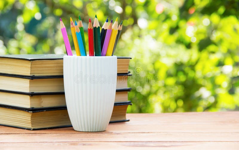 https://thumbs.dreamstime.com/b/stack-books-stack-colored-pencils-green-natural-background-white-porcelain-cup-ribbed-surface-stationery-77020330.jpg