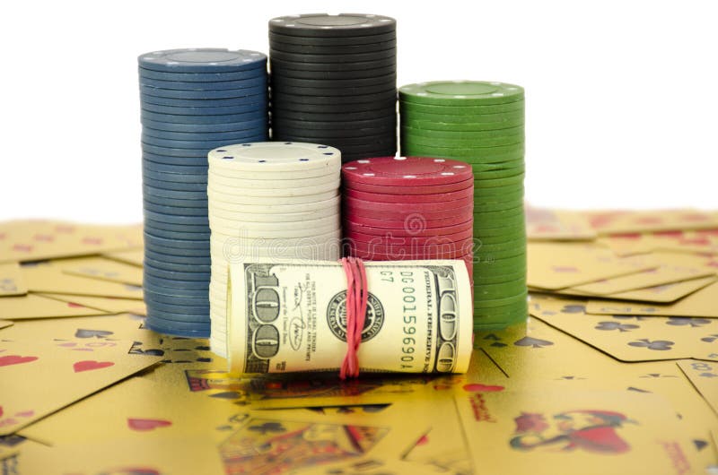 A stack of chips stays on gold cards with roll of dollars isolated on whitte background.