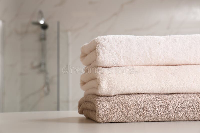 Stack of Clean Towels on Table in Bathroom, Closeup. Stock Image