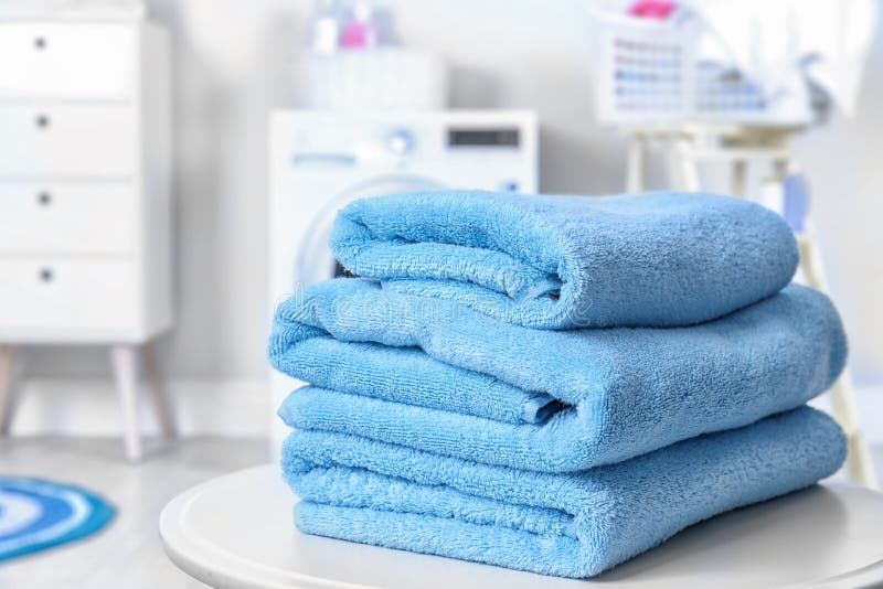 Stack of Clean Towels on Table in Laundry Room. Stock Photo Image of