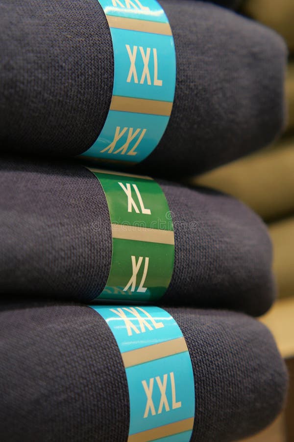 Stack of clothing items with size labels in retail store royalty free stock photos