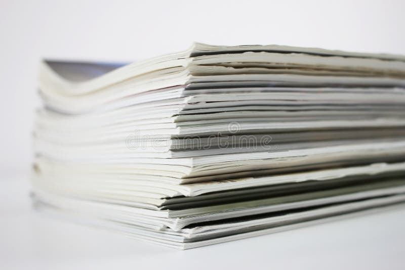 A stack of colored magazines on a white background, angle. A stack of colored magazines on a white background, angle