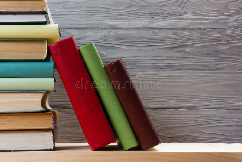 Stack of colorful books on wooden table. Back to school. Copy space