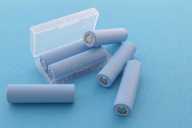 Stack of 18650 cylindrical batteries on blue background stock images
