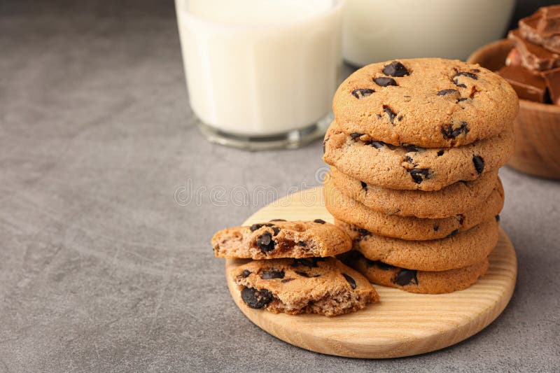 Stack of Delicious Chocolate Chip Cookies and Milk on Grey Table. Space