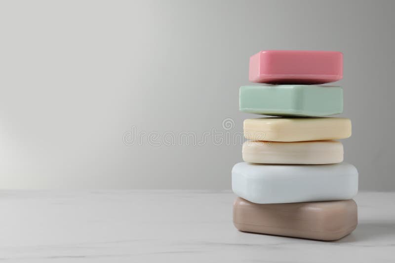 Stack of different soap bars on white marble table. Space for text royalty free stock images