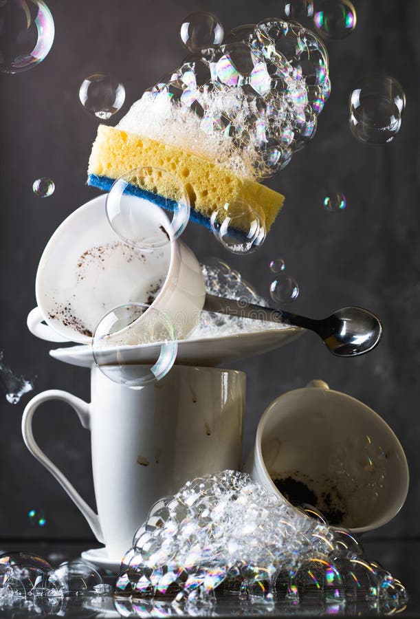 Stack of Dirty White Dishes on Dark Background with Washing Sponge and