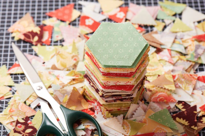 Hexagon english paper piecing templates, white cup, thread, retro scissors  and metal pins on the wooden table Stock Photo