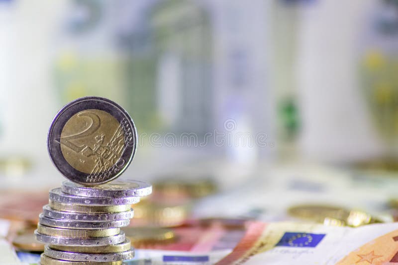 Stack of european coins and bank notes in the background show international finance with euro and europe and european trade