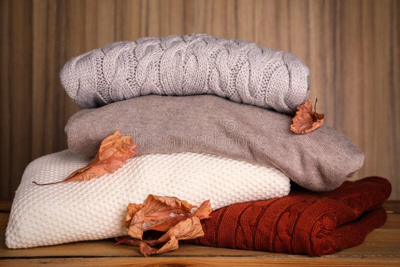 Stack of Folded Knitted Sweaters and Autumn Leaves Against Wooden ...