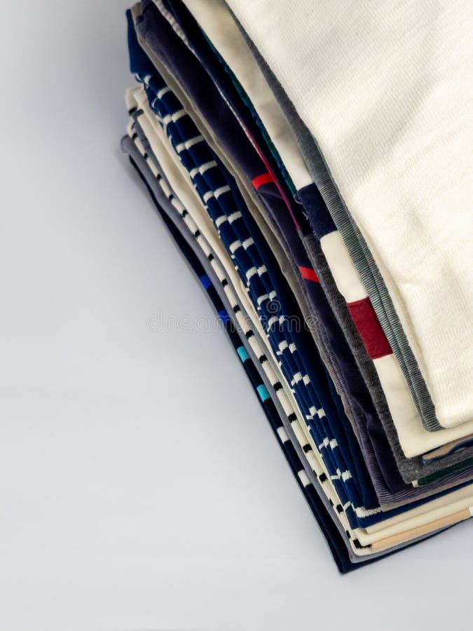 Stack of Folded Towels in Various Colors and Designs on White Surface stock photography