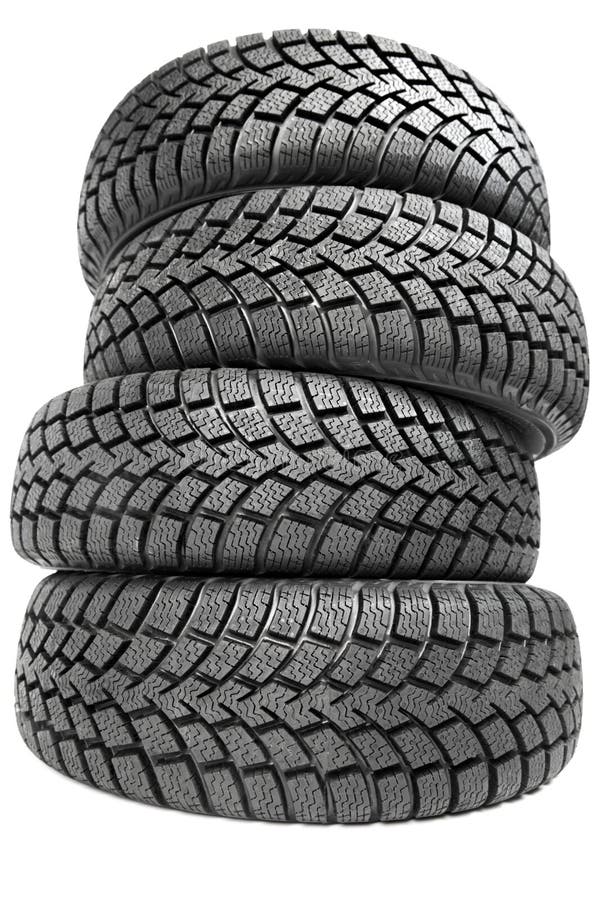 Stack of four car wheel winter tires isolated