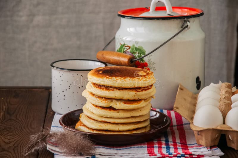 Stack of Homemade Pancakes in a Plate, Milk in a Flask, Eggs in Stock