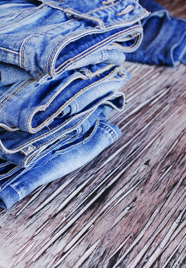 Stack of Jeans Lying on a Wooden Table Stock Photo - Image of denim ...