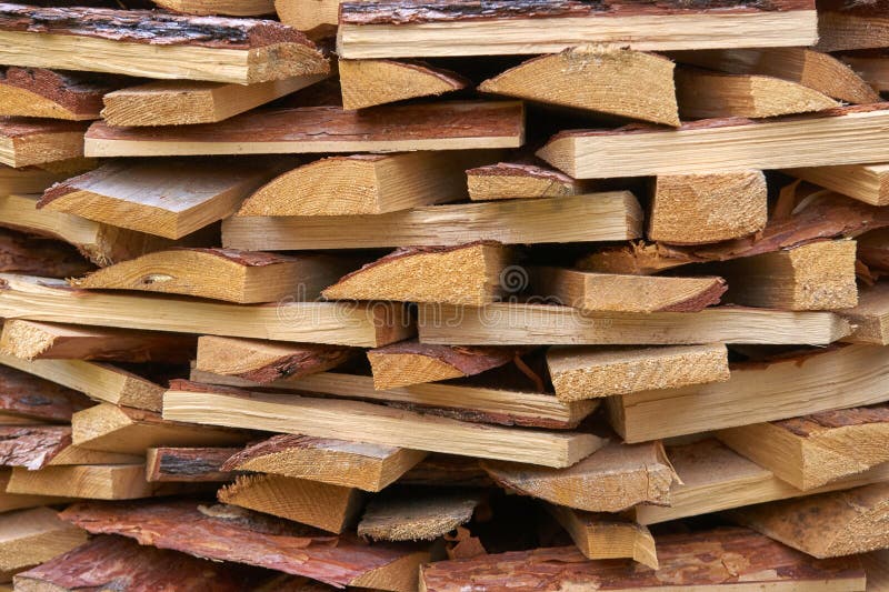Stack of natural wooden planks with rough edges and bark for construction stock photo