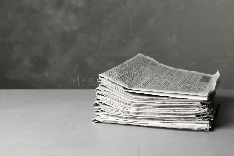 Stack of Newspapers on Light Grey Stone Table, Space for Text