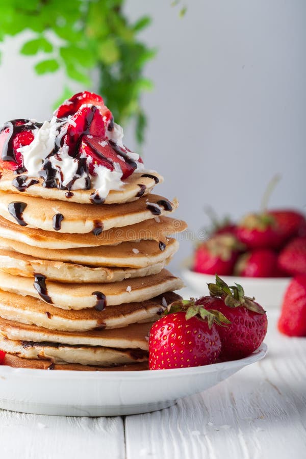 Stack Of Pancakes With Strawberries, Whip Cream And Chocolate Syrup On