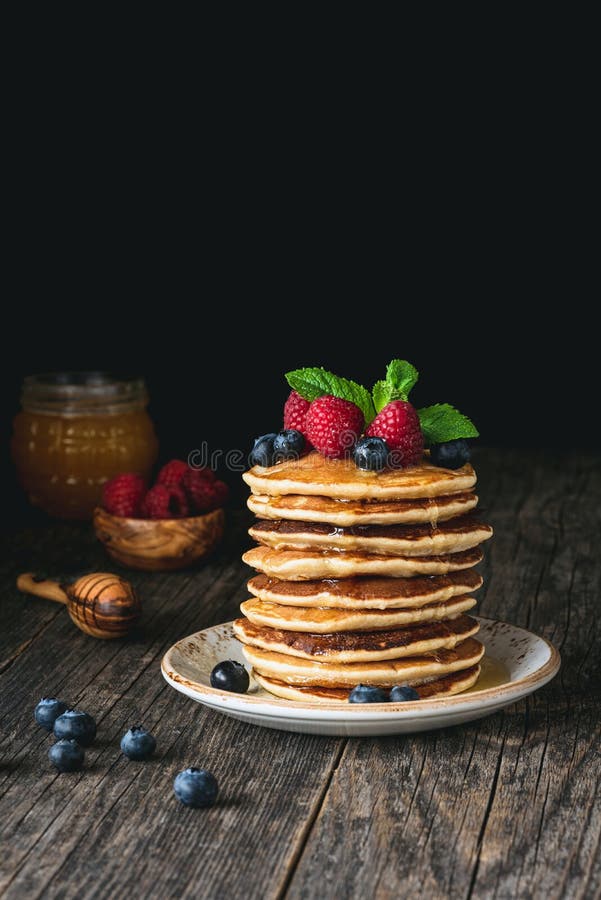 Rustic Breakfast Pancakes On A Dark Plate With Blueberries And Honey ...