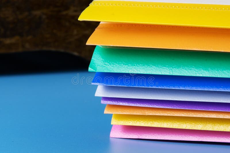 A Row of Multicolored Plastic Folders for Paper on a Blue Background