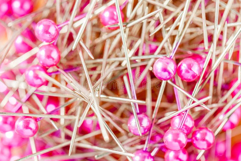 Stack of pink sewing pins in the box.