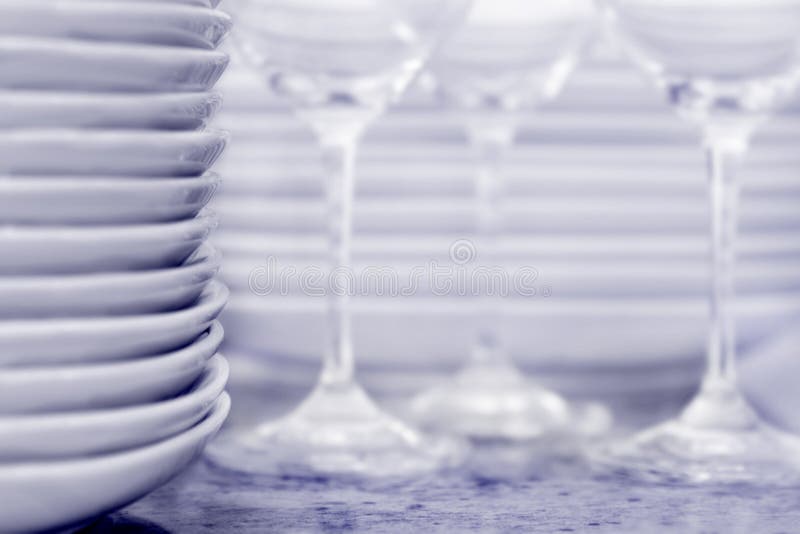 Stack of plates with wineglasses and more plates i