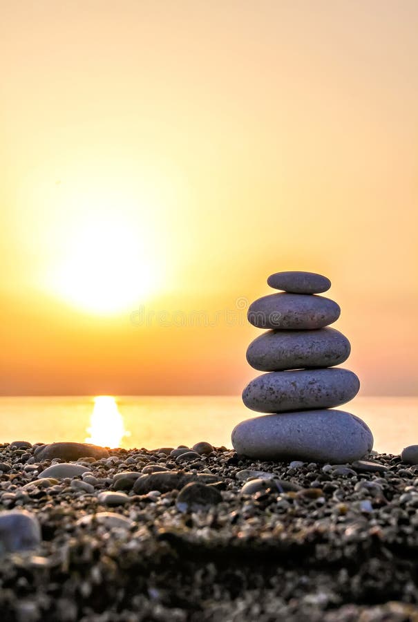 Stack of stones against golden sunset