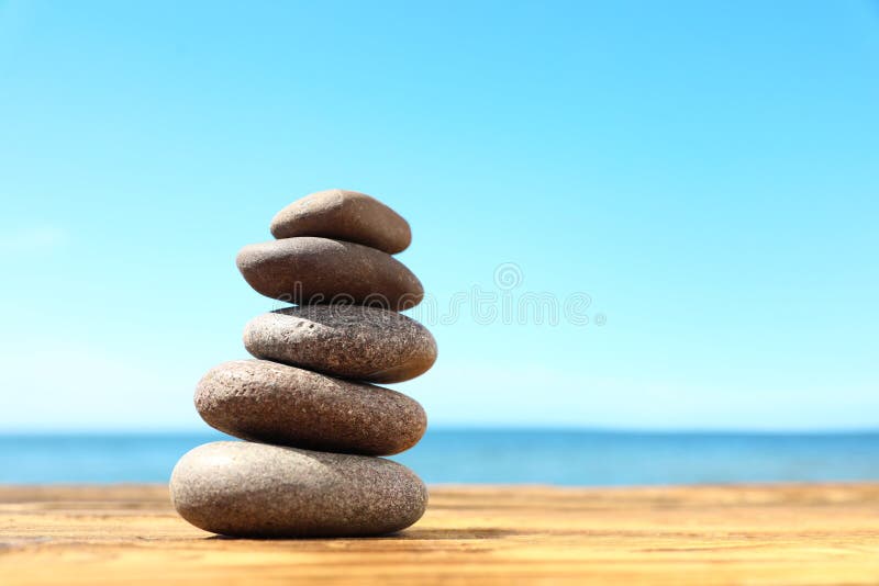 Stack Of Stones On Wooden Table Against Seascape Zen Concept Stock Stack Of Stones On Wooden Table Against Seascape Zen Concept Stock