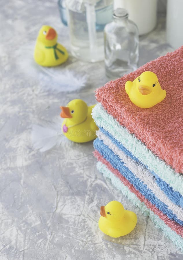 Stack of Towels with Yellow Rubber Bath Ducks on White Marble