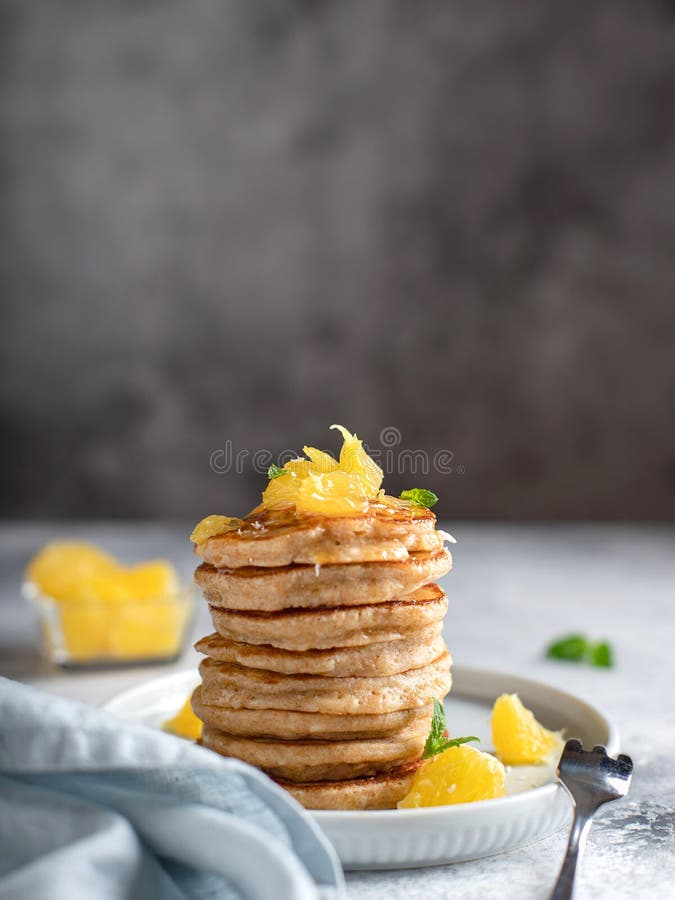 Stack of Whole Grain Flour Pancakes, Decorated with Orange and Mint