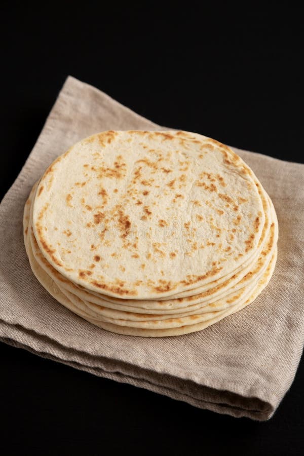 Stack of Whole Wheat Flour Tortillas on a Black Background, Side View