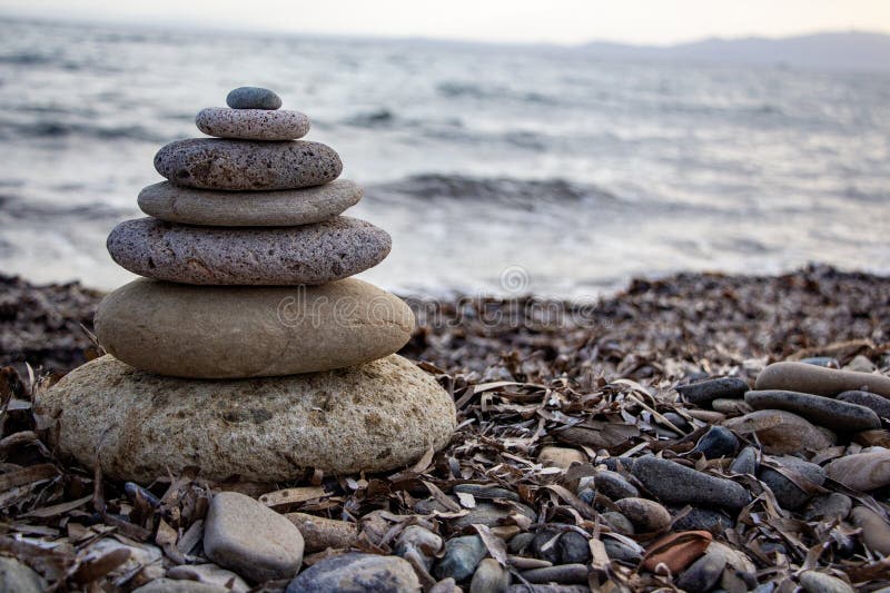 Stack of zen stones on the beach. Zen and harmony concept. Pyramid of pebbles on the beach at sunset. stock photo