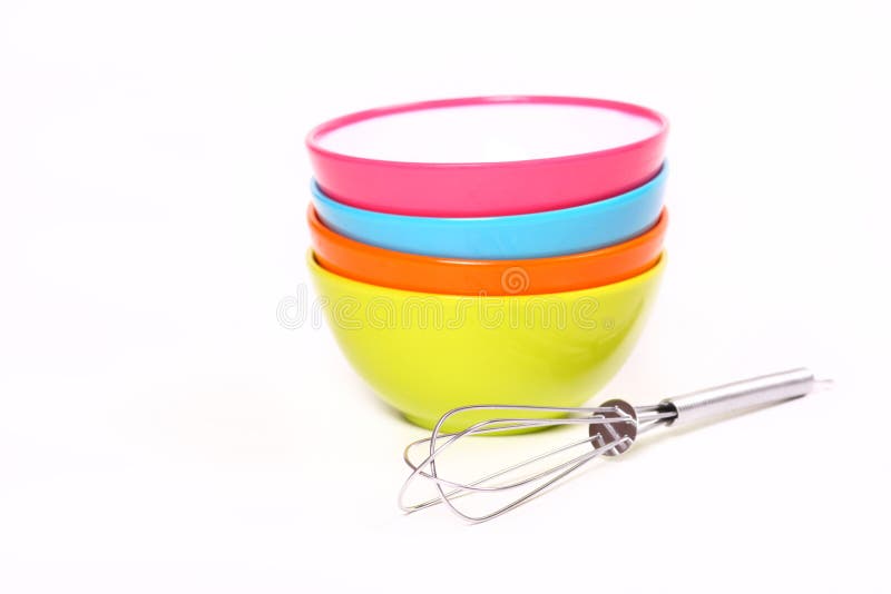 4 bright colored mini bowls with a wire wisk isolated on white. 4 bright colored mini bowls with a wire wisk isolated on white
