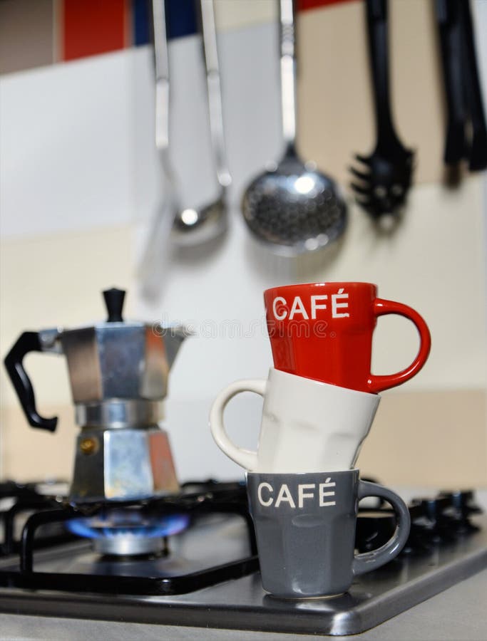 Red Coffee Cup and Vintage Coffeepot on Kitchen Stove Stock Photo