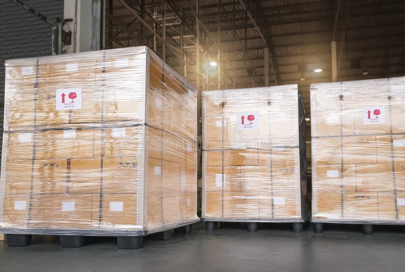 Stacked of Package Boxes Wrapped Plastic Flim on Plastic Pallets at Storage Warehouse. Shipment Boxes. Cargo Export- Import.