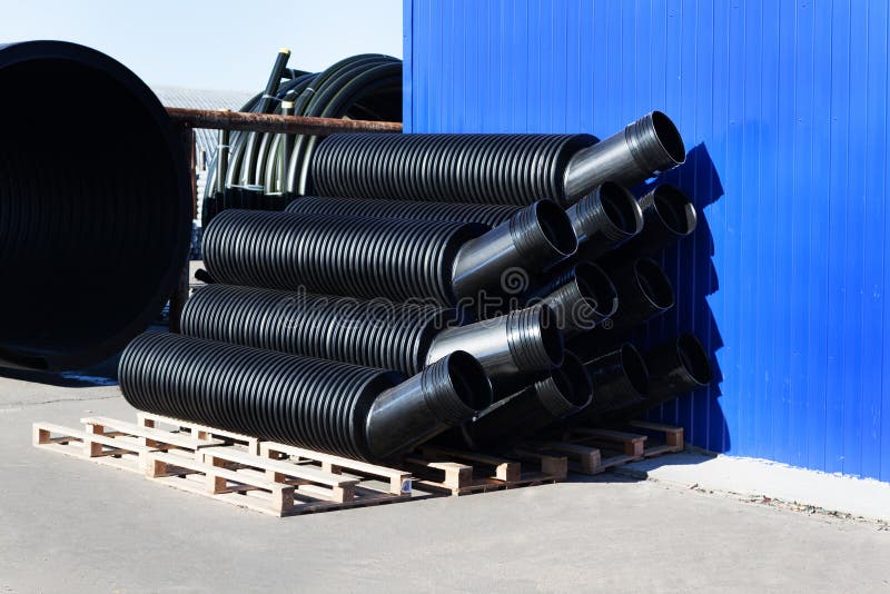 Stacks of Black Pvc Plastic Pipe Outdoors with Selective Focus Stock