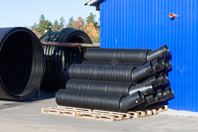 Stacks of Black Pvc Plastic Pipe Outdoors with Selective Focus Stock