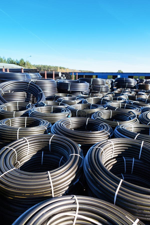 Stacks of Black Pvc Plastic Pipe Outdoors with Selective Focus Stock