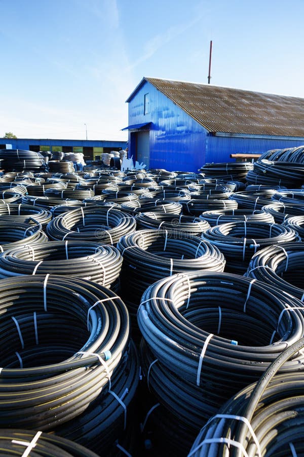 Stacks of Black Pvc Plastic Pipe Outdoors with Selective Focus Stock