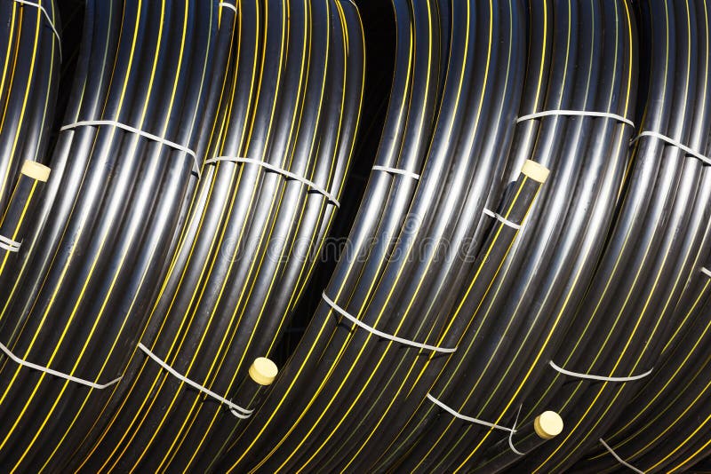 Stacks of Black Pvc Plastic Pipe Outdoors with Selective Focus Stock